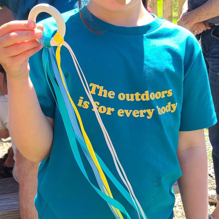 a blue t-shirt reads, "the outdoors is for every body"