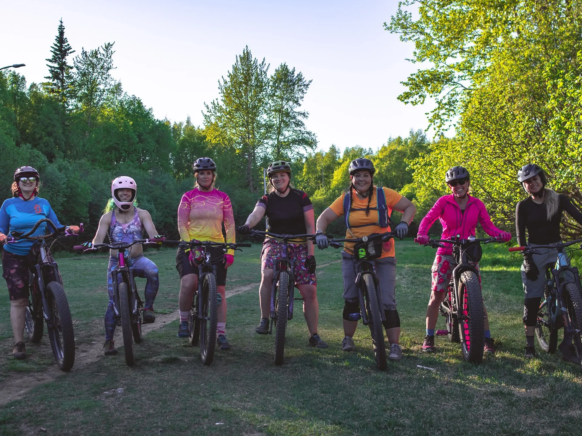 a group of women pose on bikes