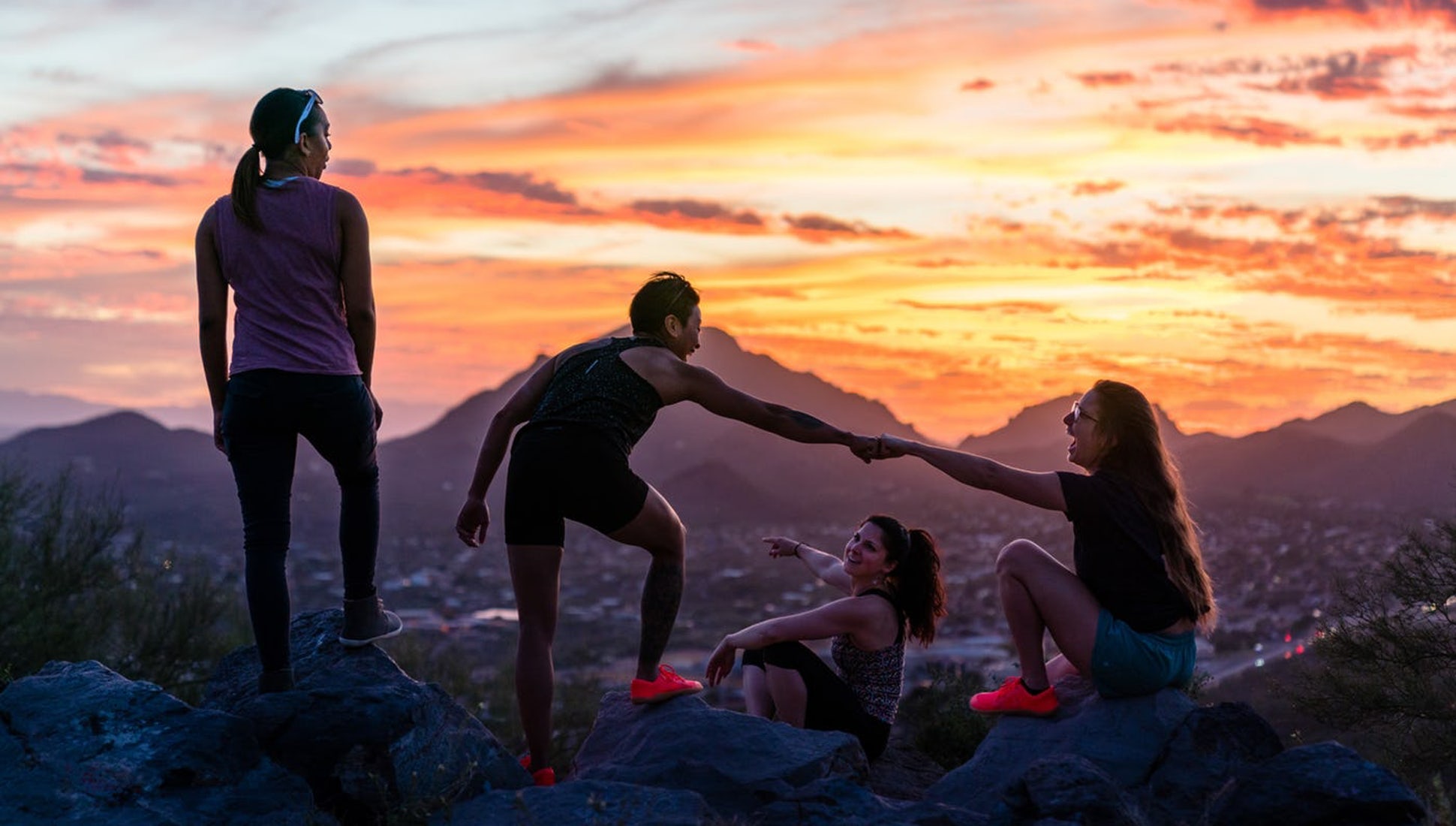 people gather on a mountain during the sunset