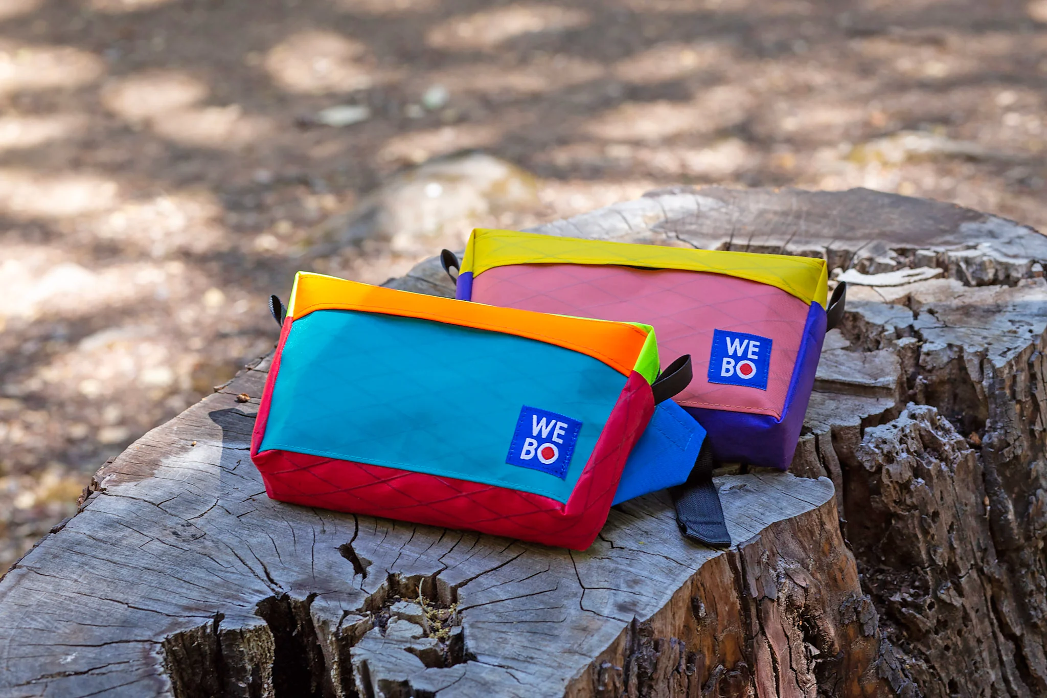 colorful hip pouches are displayed on a stump