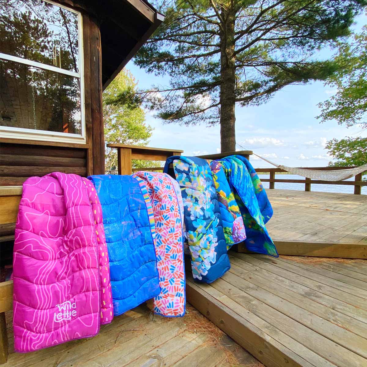 colorful blankets are arranged on a bannister of a cabin